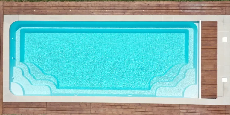 Photo de la grande piscine 10x4 avec double escalier latéral Grand Lac en coque polyester à fond plat alvéolé