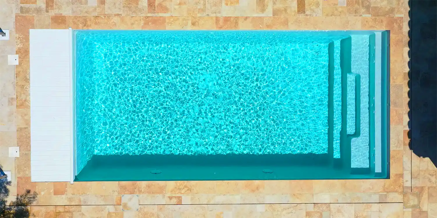Photo de la piscine 8x4 m. et sa banquette immergée Lac de Nantua en coque polyester à fond plat alvéolé